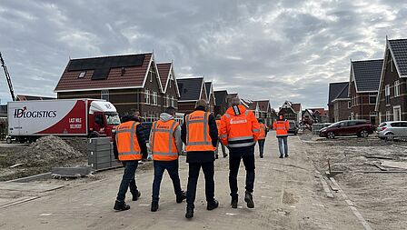 De deelnemers worden rondgeleid bij het nieuwbouwproject ‘De Eilanden’ in de gemeente Dijk en Waard.
