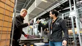 Twee Werknemers Steken De Duim Naar Elkaar Op In Magazijn