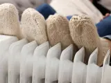 Voeten met gebreide sokken op een radiator