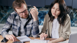 Man en vrouw zoeken samen naar een oplossing voor schulden.