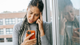 Jonge vrouw vraagt om hulp via de telefoon.